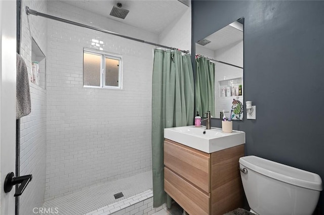 bathroom with a shower stall, toilet, and vanity