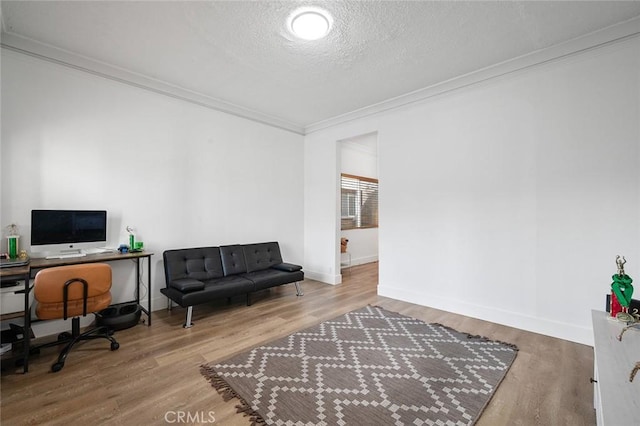 home office featuring wood finished floors, a textured ceiling, crown molding, and baseboards