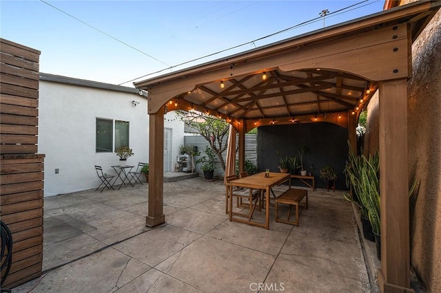 view of patio / terrace featuring fence, a gazebo, and outdoor dining space