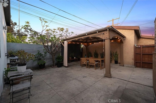 view of patio / terrace featuring a fenced backyard, a gazebo, and outdoor dining space