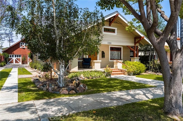 craftsman-style home with covered porch and a front yard