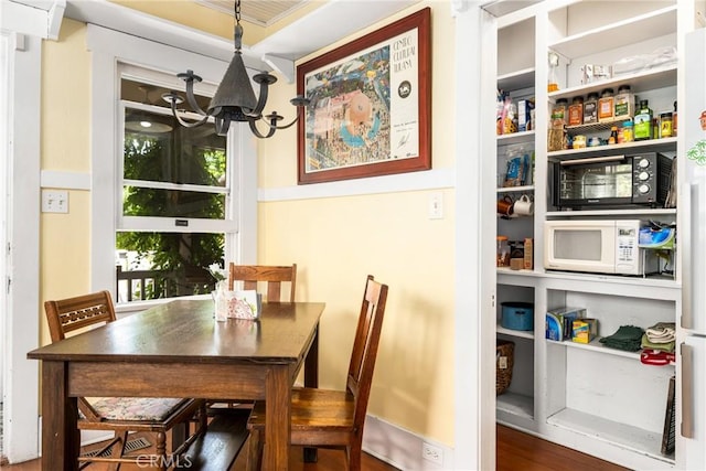 dining room featuring a notable chandelier and dark wood-type flooring