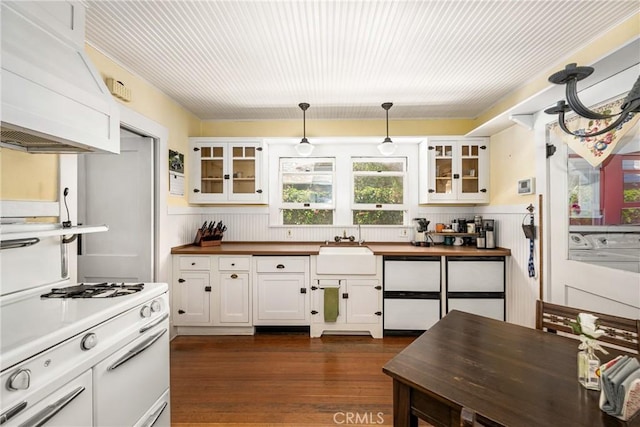 kitchen featuring custom range hood, dark wood-type flooring, sink, white cabinets, and hanging light fixtures