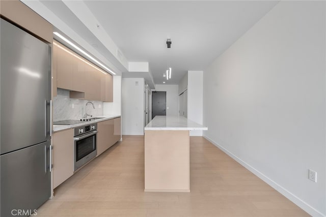 kitchen featuring sink, light hardwood / wood-style flooring, decorative backsplash, and stainless steel appliances