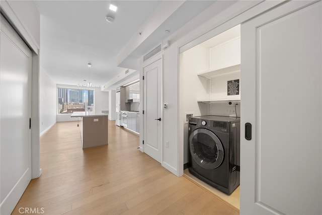 laundry room featuring light hardwood / wood-style flooring and washer / dryer