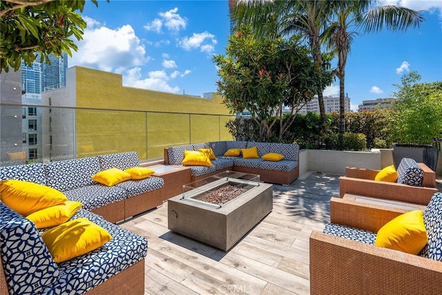 wooden terrace featuring an outdoor living space with a fire pit