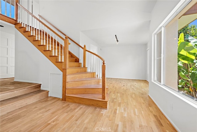 staircase with light hardwood / wood-style floors and plenty of natural light