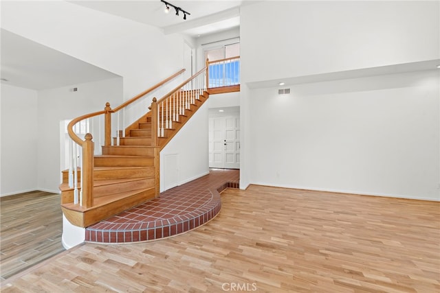 1585 Catalina, Laguna Beach, CA 92651 - staircase with wood finished floors, baseboards, a towering ceiling, and track lighting
