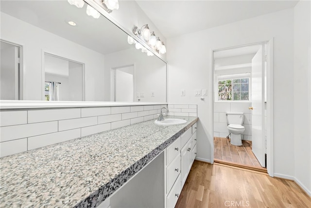 1585 Catalina, Laguna Beach, CA 92651 - bathroom featuring toilet, wood finished floors, vanity, tile walls, and decorative backsplash