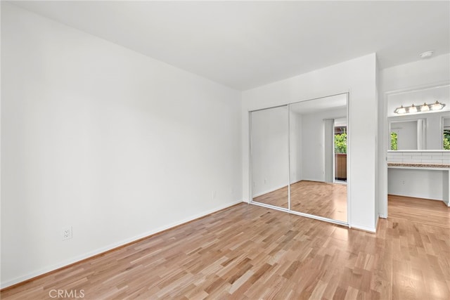 unfurnished bedroom featuring a closet and light hardwood / wood-style flooring