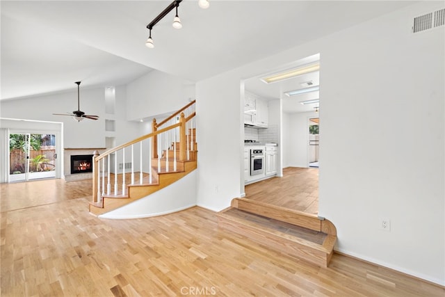 1585 Catalina, Laguna Beach, CA 92651 - entrance foyer with a glass covered fireplace, stairs, a ceiling fan, light wood-type flooring, and vaulted ceiling