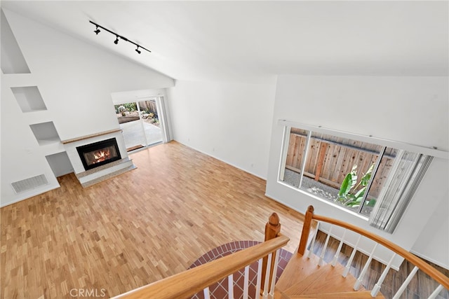 1585 Catalina, Laguna Beach, CA 92651 - living area with track lighting, wood finished floors, vaulted ceiling, and a glass covered fireplace