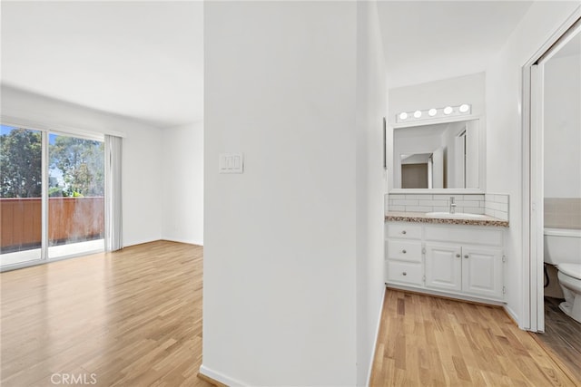 bathroom with hardwood / wood-style floors, vanity, and toilet