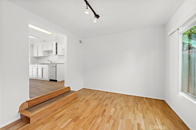 spare room featuring light hardwood / wood-style flooring and rail lighting