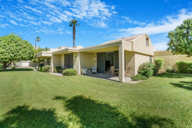 rear view of property with a yard and a patio