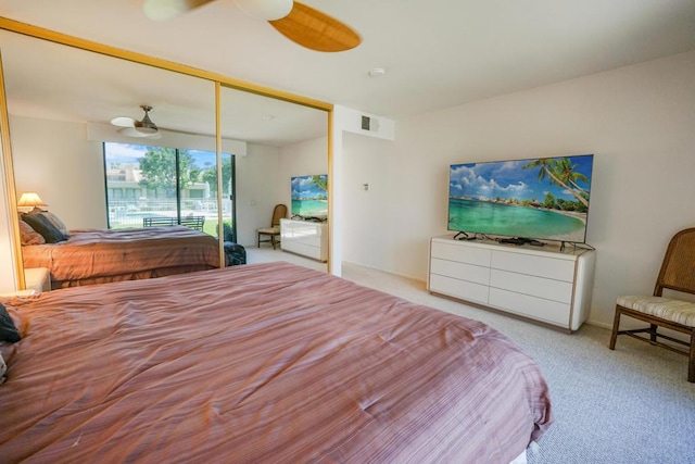 bedroom with ceiling fan, a closet, and light carpet