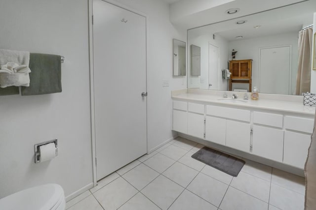 bathroom with tile patterned flooring, vanity, and toilet