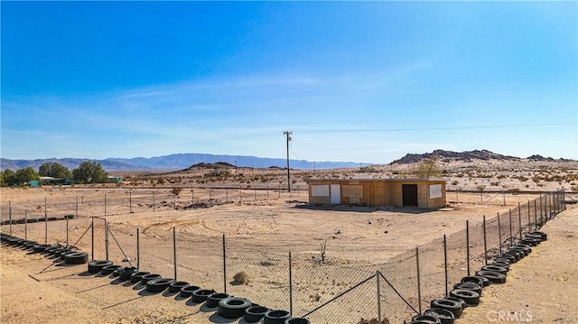 view of yard with a mountain view, an outdoor structure, and a rural view