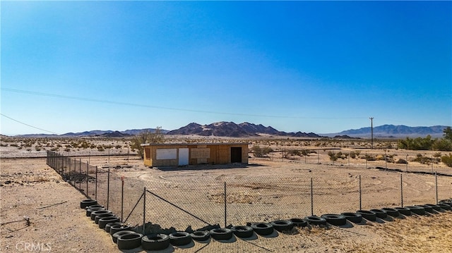 view of yard featuring a rural view, a mountain view, and an outbuilding