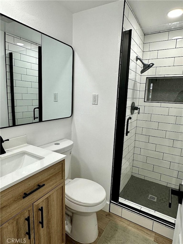 bathroom with vanity, wood-type flooring, an enclosed shower, and toilet