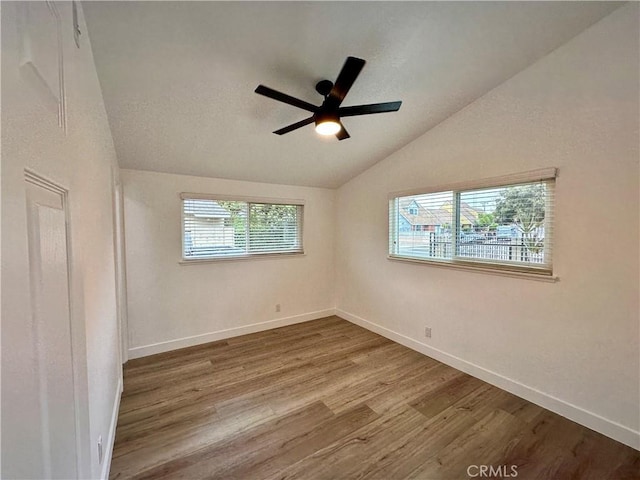 empty room featuring ceiling fan, lofted ceiling, and hardwood / wood-style flooring