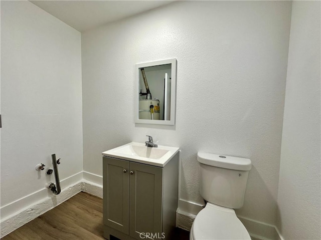 bathroom with hardwood / wood-style floors, vanity, and toilet