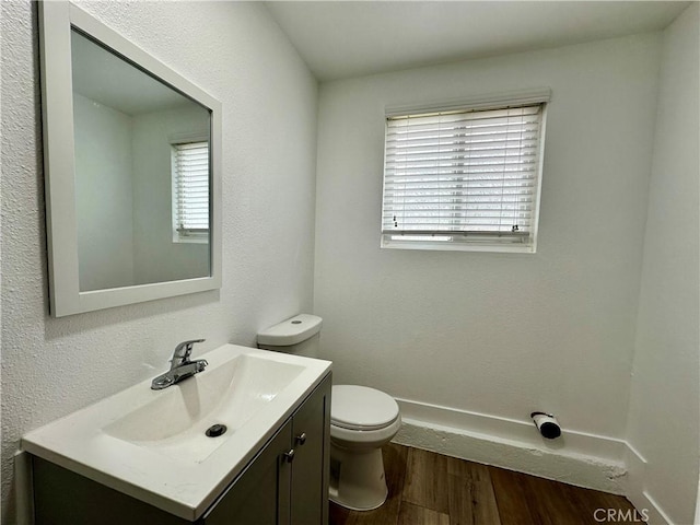 bathroom with hardwood / wood-style floors, vanity, toilet, and plenty of natural light