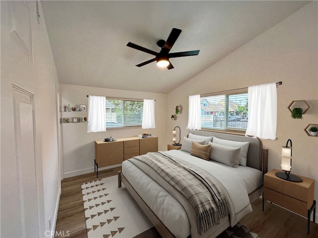 bedroom with ceiling fan, wood-type flooring, and lofted ceiling