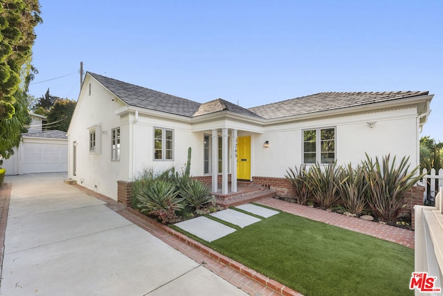 view of front of home featuring a front yard, a garage, and an outdoor structure