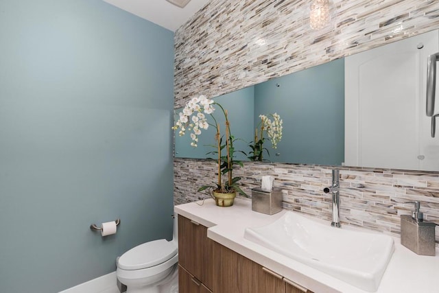 bathroom with decorative backsplash, vanity, and toilet