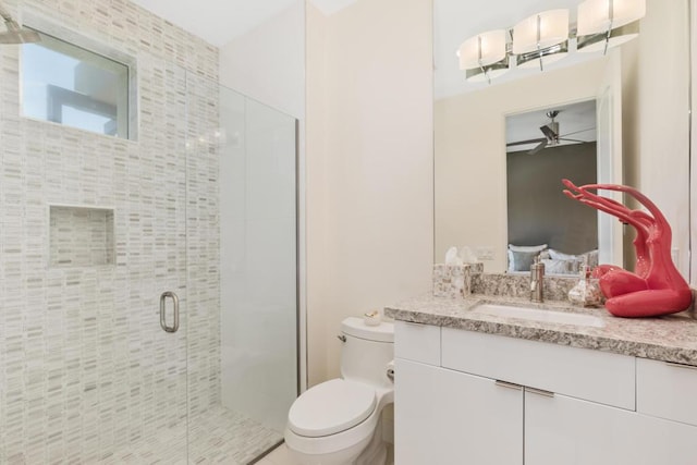 bathroom with an enclosed shower, vanity, ceiling fan, and toilet