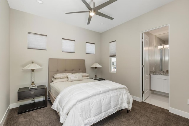 bedroom featuring dark colored carpet, connected bathroom, and ceiling fan