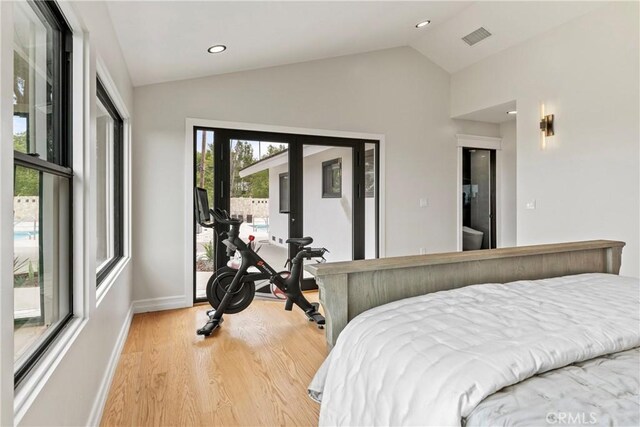 bedroom with lofted ceiling, light wood-type flooring, and access to outside