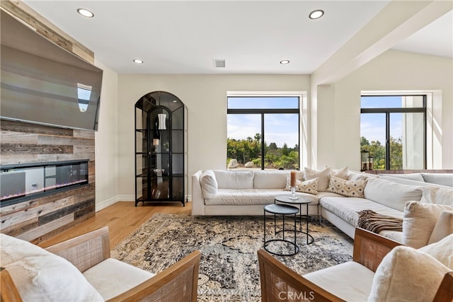 living room featuring light wood-type flooring and vaulted ceiling