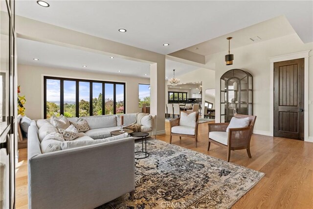 living room featuring a notable chandelier and light wood-type flooring