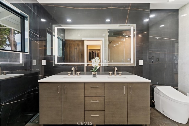 bathroom with tasteful backsplash, tile walls, dual vanity, and toilet