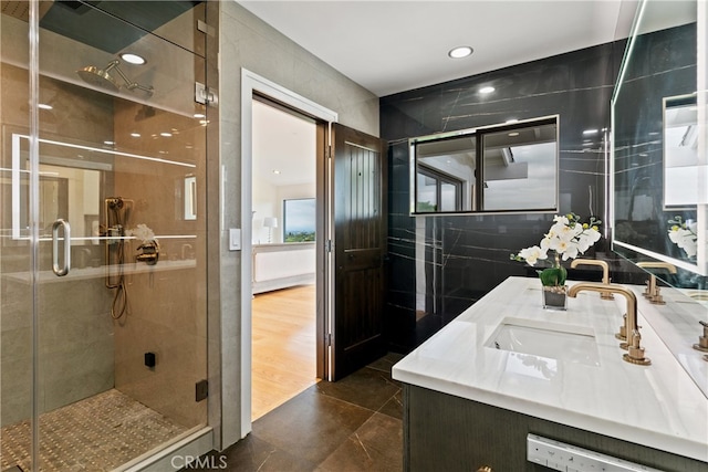 bathroom featuring wood-type flooring, tile walls, vanity, and walk in shower