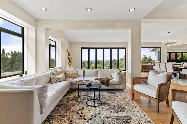 living room featuring a notable chandelier, hardwood / wood-style flooring, and a healthy amount of sunlight