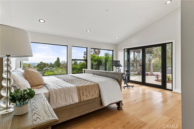 bedroom featuring high vaulted ceiling, access to outside, light hardwood / wood-style floors, and french doors