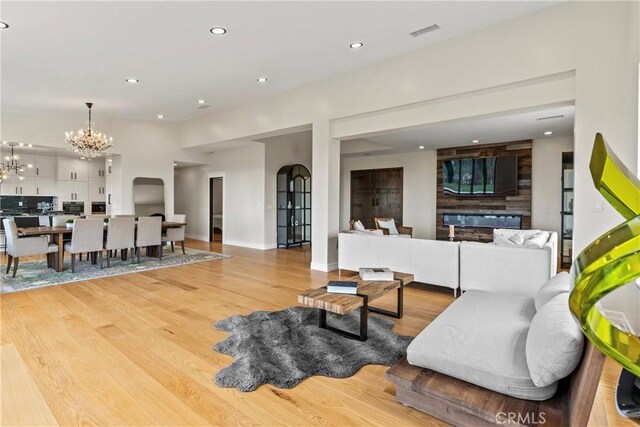 living room featuring an inviting chandelier and light hardwood / wood-style floors