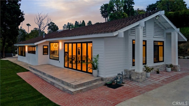 back house at dusk with a patio