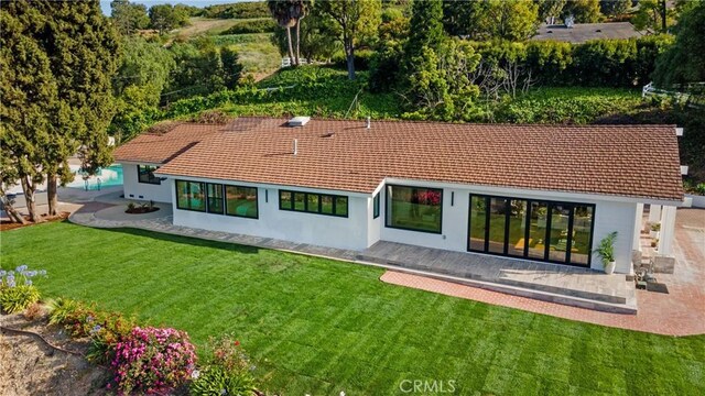 rear view of property featuring a patio and a yard