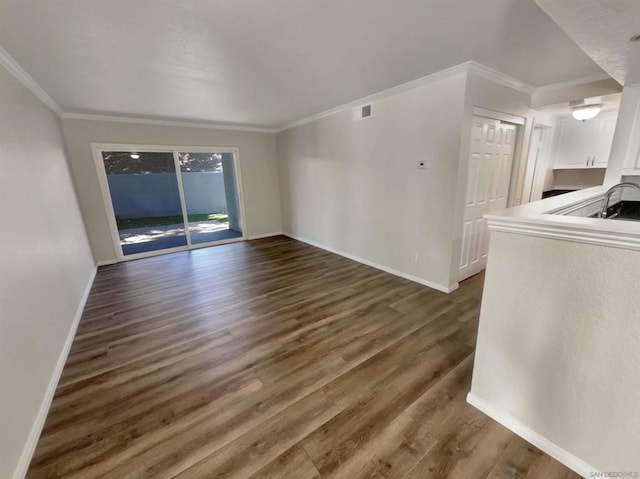 unfurnished living room featuring ornamental molding and dark wood-type flooring