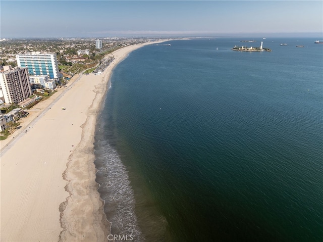 birds eye view of property with a water view and a beach view