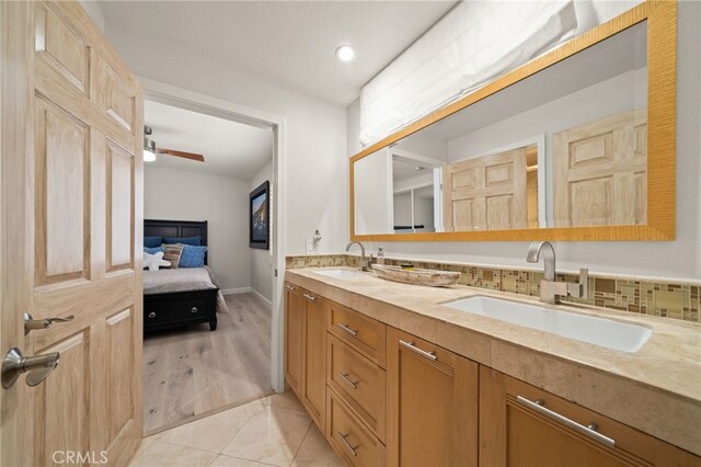 bathroom with tile patterned floors, vanity, and decorative backsplash