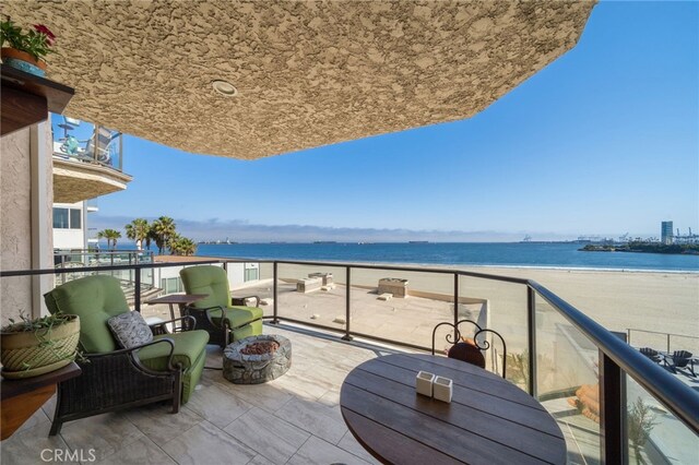 balcony with a water view and a beach view