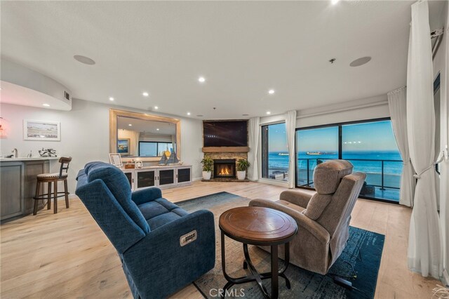 living room featuring light hardwood / wood-style floors, sink, and a fireplace