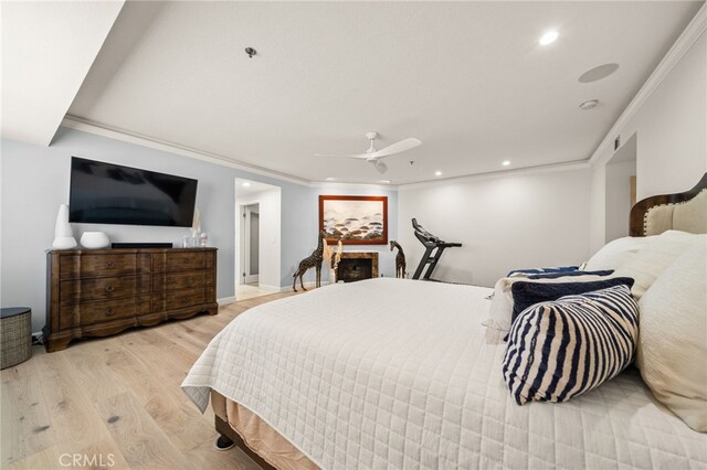 bedroom featuring light hardwood / wood-style floors, ceiling fan, and crown molding