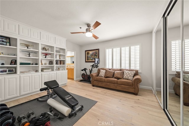 exercise area with ceiling fan, plenty of natural light, baseboards, and light wood-style floors