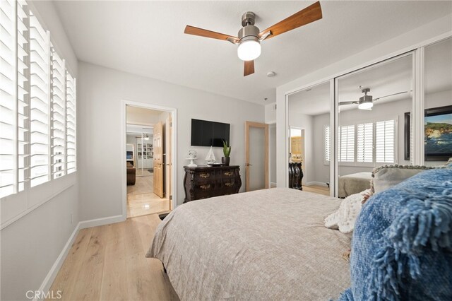 bedroom with light wood-type flooring, a closet, and ceiling fan